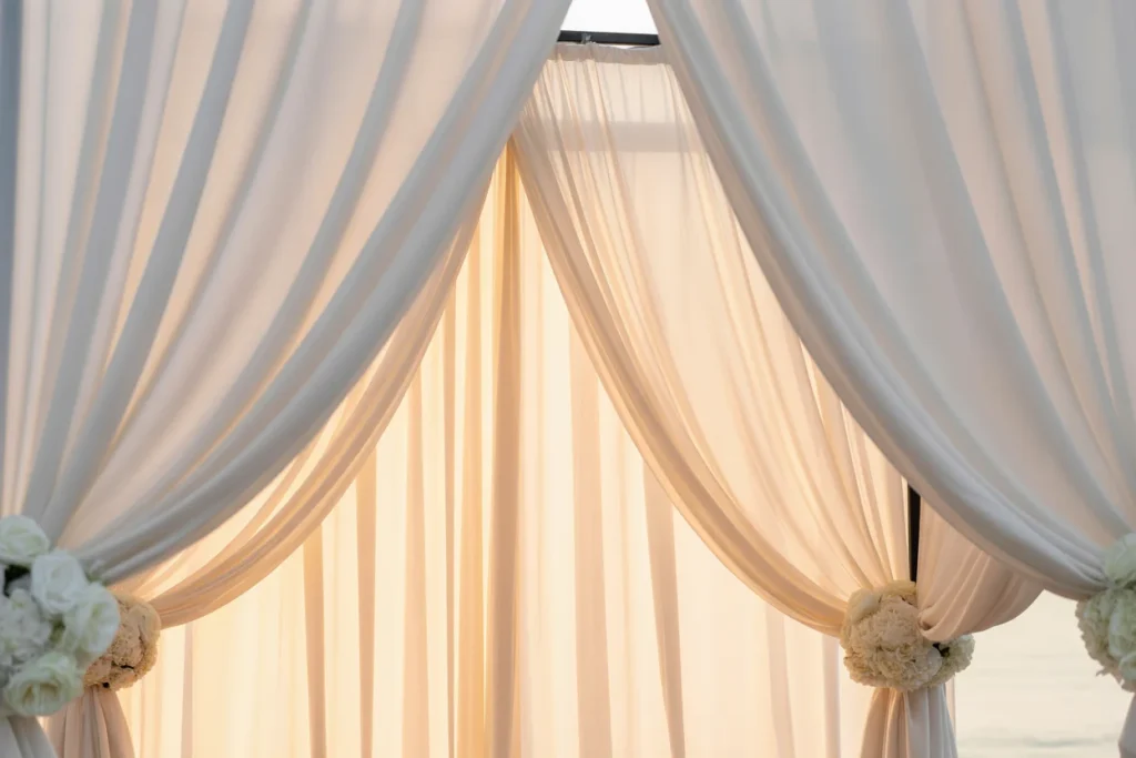 : white drapes engagement decor, elegant minimalist setup, romantic atmosphere, soft lighting
